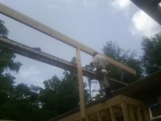 Carpenter setting a ridge beam over a new addition frame — Ice Dam Removal by Roofing Brothers in Campton
