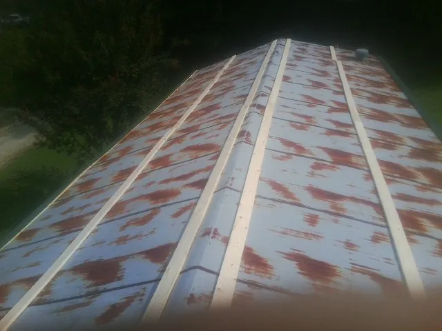 Rusted metal roof panels with new wood purlins before replacement — Storm Damage Roof Repair in Campton by Roofing Brothers