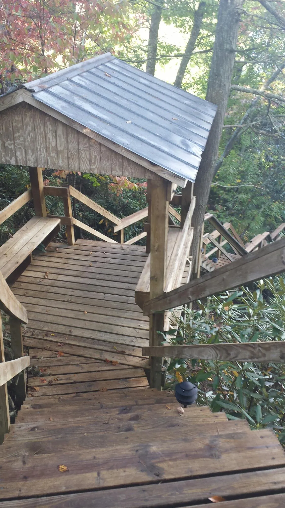 Metal roofed shelter over wooden steps on a wooded walkway — Skylight Repair & Installation work by our crew in Campton