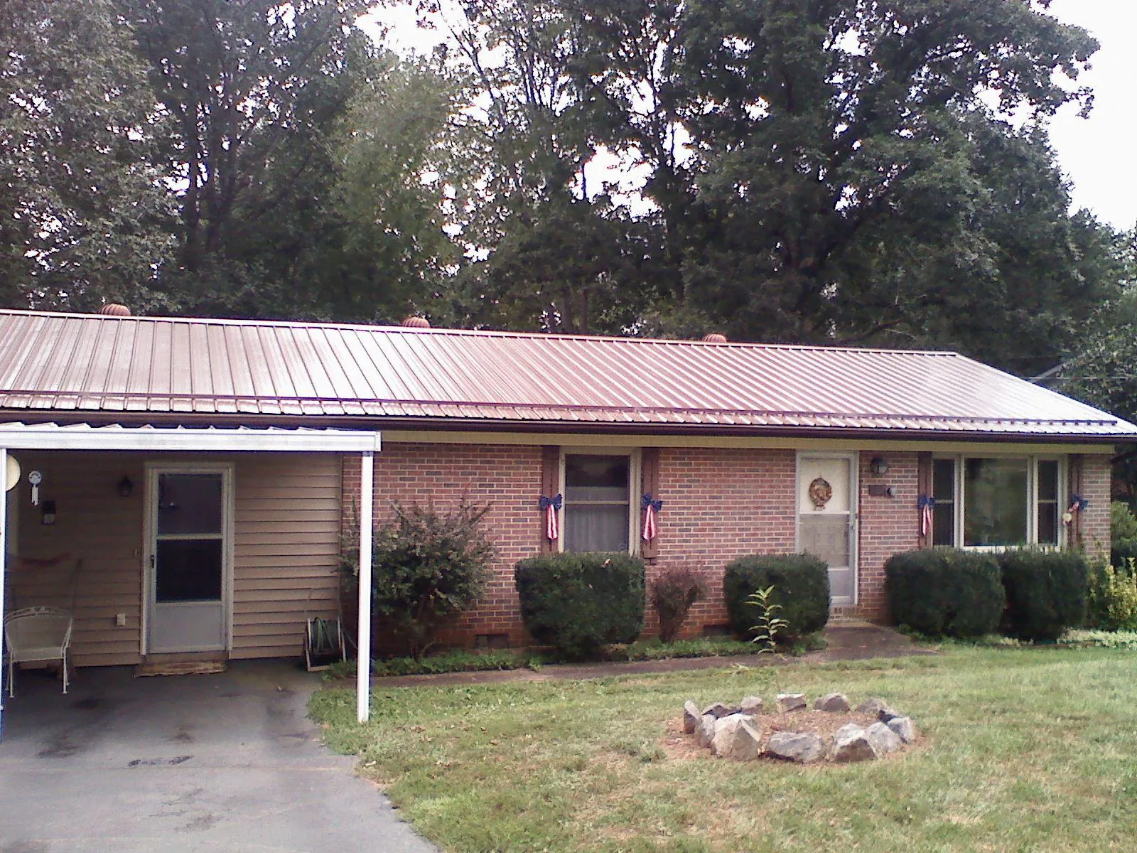 Bronze metal roof and carport on a brick ranch home — Roof Repair work by our crew in Campton